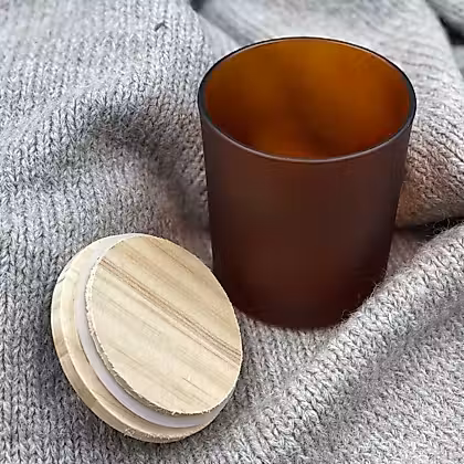 Glass jars beside wooden lid on fabric background
