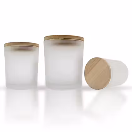 three glass jars with wooden lids on a white surface