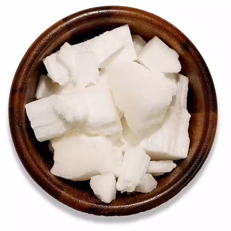 Flocons de cire de noix de coco dans un bol en bois sur fond blanc