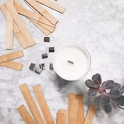 wooden sticks and a candle on a marble counter
