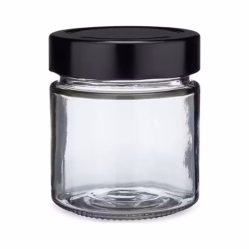 un pot en verre avec un couvercle noir sur fond blanc