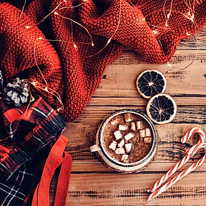 chocolat chaud avec des guimauves et des cannes de bonbon sur une table en bois