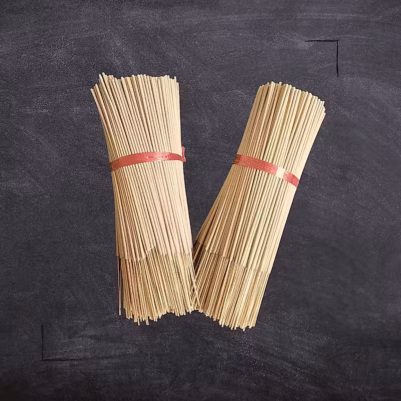 bâtons de bambou enveloppés de ruban rouge sur un tableau noir